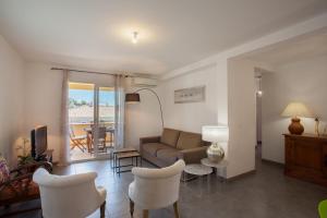 a living room with a couch and chairs and a television at Casa Chjara Maria in Vescovato
