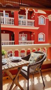 a dining room with a table and a red wall at Apartamento rojo con vistas al mar in Mazagón
