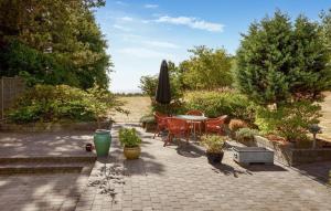 a patio with a table and chairs and an umbrella at 2 Bedroom Cozy Home In Hasle in Vysteby +6 photos