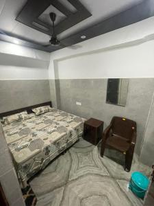 a bedroom with a bed and a chair in it at Hotel Grey Inn in Jammu +2 photos