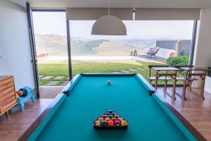 a pool table in a living room with a view at NEW!! Lugar das Letras in Sabrosa