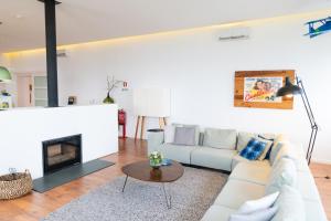 a living room with a white couch and a fireplace at Spacious Villa with Private Pool & Garden in Douro, by Hopstays in Sabrosa +83 photos