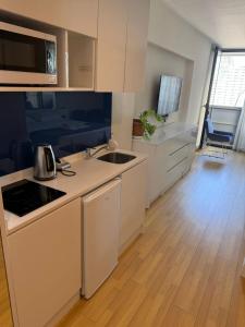 a kitchen with white cabinets and a wooden floor at Orbi City Premium Sea View Apartments in Batumi +5 photos