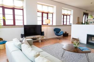a living room with a white couch and a tv at Spacious Villa with Private Pool & Garden in Douro, by Hopstays in Sabrosa