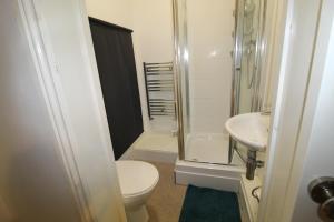 a bathroom with a toilet and a shower and a sink at Reeves House By Smart Corporate Stays in Derby