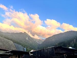 a view of a mountain range with clouds in the sky at Gîte du Nant in Sainte-Agnès