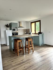 a kitchen with a counter and stools in a kitchen at Gîte du Nant in Sainte-Agnès