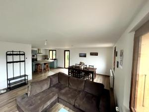 a living room with a brown couch and a table at Gîte du Nant in Sainte-Agnès