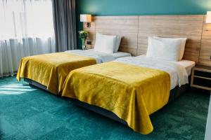 two beds sitting next to each other in a hotel room at Favor Park Hotel in Kyiv