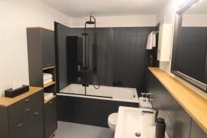 a bathroom with a tub and a sink and a toilet at Cozy City Apartments 2, 2-Room Flat for Vacation & Messe Düsseldorf, Perfect Connectivity in Ratingen +17 photos
