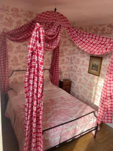 a bedroom with a bed with red and white curtains at Barabans Tower Cluny Abbay in Cluny