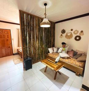 un hombre sentado en una cama en una habitación en Apartment El Nido, en El Nido