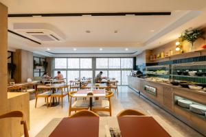 a restaurant with tables and people sitting at tables at Alves Hotel in Konak