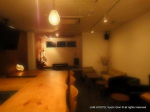 京都的住宿－京都祗園JAM旅舍，客厅配有木桌和椅子