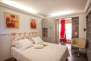a bedroom with a bed and a chair and a window at Lucamare - Casa Rossa in LʼÎle-Rousse +27 photos