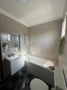 a bathroom with a tub and a toilet and a sink at Charm-In Apartments in Vila Nova de Milfontes +41 photos