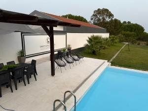 a patio with a table and chairs next to a pool at Green Gold Passion in Santo Estêvão