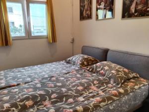 Una cama con una manta y almohadas encima en WelcomE Home, en Garachico