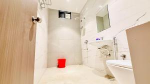 a white bathroom with a toilet and a sink at Hotel City Inn 2min Walk To Gorakhnath Temple in Gorakhpur