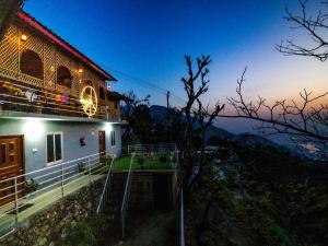 a house with a view of a mountain at night at Blissful Mountain Kyarki in Shivpuri