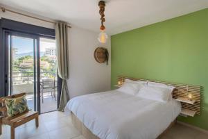 una camera con un letto bianco e una parete verde di Playa Marina a Bastia