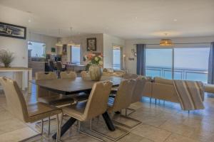 a dining room and living room with a table and chairs at Villa Carlisa in Algajola