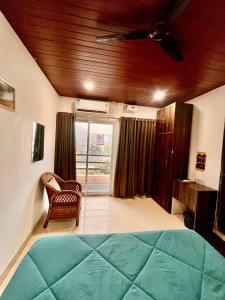 a bedroom with a bed and a chair and a window at Vortex homes in Guwahati