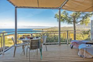 a deck with a table and chairs and a view of the ocean at Casa Lucia in Algajola