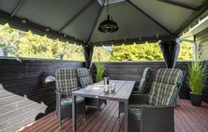 una mesa y sillas en una terraza con sombrilla en 3 Bedroom Amazing Home In Slagelse, en Drøsselbjerg