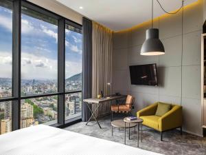 a bedroom with a bed and a desk and a chair at Pullman Tbilisi Axis Towers in Tbilisi City