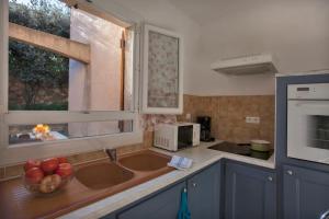 une cuisine avec un évier et une fenêtre dans l'établissement Domaine Bollaccia - Casa Ostriconi, à Monticello