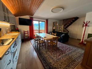 a kitchen and dining room with a table and chairs at Casa Latemar in Moena