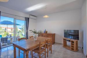 une salle à manger avec une table en bois et une télévision dans l'établissement Domaine Bollaccia - Casa Ostriconi, à Monticello