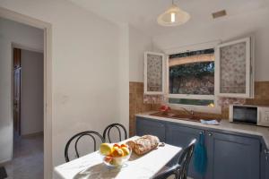 une cuisine avec une table avec un bol de fruits dessus dans l'établissement Domaine Bollaccia - Casa Ostriconi, à Monticello