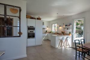 a kitchen with white appliances and a table and chairs at Casa Marinu Muntese in Erbalunga