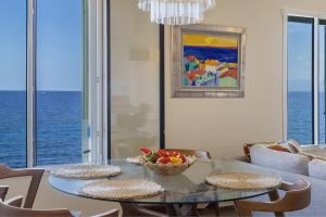 ein Esszimmer mit einem Glastisch und einer Obstschale in der Unterkunft Casa Bordimare Miomo Cap Corse in La Vasina