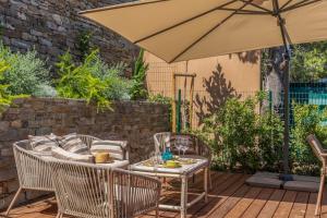 eine Terrasse mit Sonnenschirm und Tisch und Stühlen in der Unterkunft Casa Bordimare Miomo Cap Corse in La Vasina + 30 Fotos