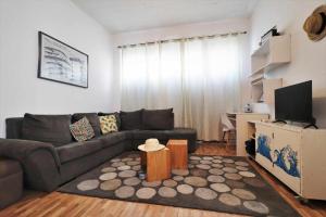 ein Wohnzimmer mit Sofa und Tisch in der Unterkunft Costa Norte Guesthouse in Ribeira Grande