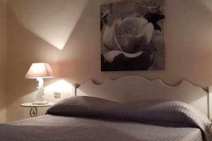 a bedroom with a bed and a painting on the wall at Appartamento a picco sul mare "La Meridiana" in Capoliveri