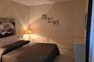a bedroom with a bed and a lamp on the wall at Appartamento a picco sul mare "La Meridiana" in Capoliveri