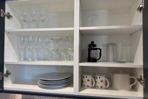 um armário cheio de copos, xícaras e pratos em Cottage - Sleeps 2 - Pet friendly - Parking em Windermere mais 4 fotografias