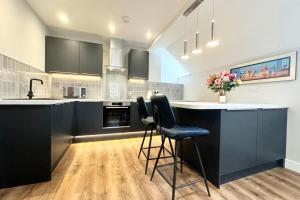 uma cozinha com armários pretos e um balcão com bancos em Cottage - Sleeps 2 - Pet friendly - Parking em Windermere