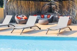 Tres tumbonas y una piscina con chimenea. en Villa Mathilda Di Porto-Vecchio, en Lecci