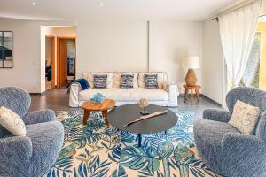 Una sala de estar con un sofá y dos sillas y una mesa. en Villa Mathilda Di Porto-Vecchio, en Lecci