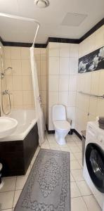 La salle de bains est pourvue d'une baignoire, de toilettes et d'un lave-linge. dans l'établissement Luxury Nightlights NELLI Apartment, à Tallinn