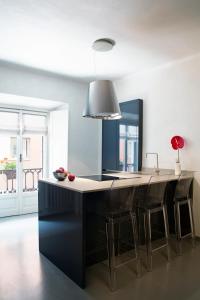 a kitchen with a black island with bar stools at Solferino Suite in Milan