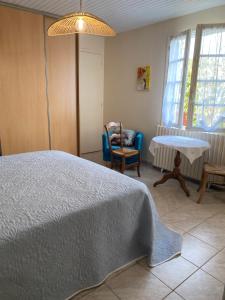 a bedroom with a bed and a table and chairs at La maison bleue in Sauveterre-la-Lémance