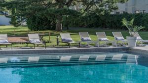 a row of lounge chairs next to a swimming pool at Apple Hotel & Konferens Göteborg in Gothenburg