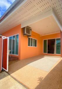 an empty house with an orange wall at Chalong pool villa in Ban Na Bon