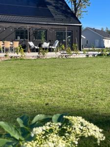 a house with a yard with chairs and a building at Villa Golfgatan 32 Vintrosa Lanna in Vintrosa